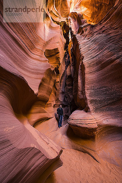 Mann steht in einem Slot Canyon  bekannt als Canyon X  in der Nähe von Page; Arizona  Vereinigte Staaten von Amerika