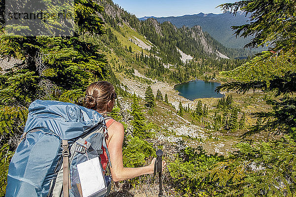 Rucksacktouristin auf dem High Divide Trail mit Blick auf den Round Lake im Sommer  Seven Lakes Basin  Olympic National Park  Olympic Mountains; Washington  Vereinigte Staaten von Amerika