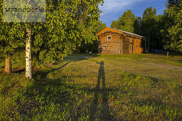 Slaven's Roadhouse an einem sonnigen Sommerabend mit dem Schatten einer winkenden Person  Yukonâ€ Charley Rivers National Preserve; Alaska  Vereinigte Staaten von Amerika