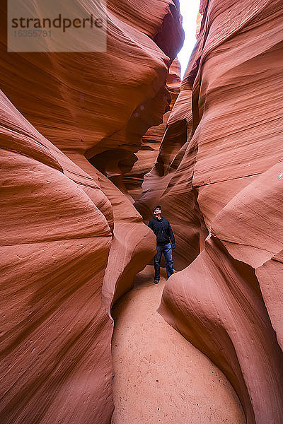 Mann steht in einem Slot Canyon  bekannt als Canyon X  in der Nähe von Page; Arizona  Vereinigte Staaten von Amerika