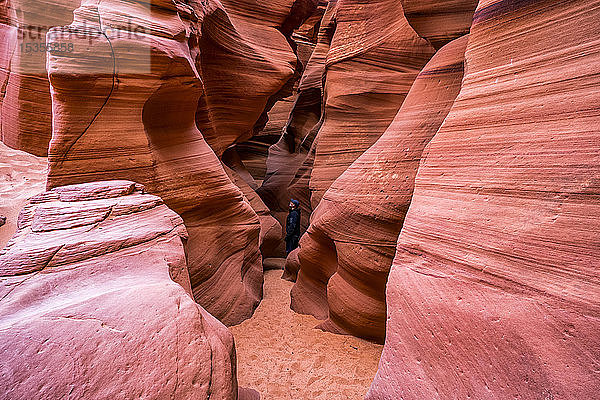 Mann steht in einem Slot Canyon  bekannt als Canyon X  in der Nähe von Page; Arizona  Vereinigte Staaten von Amerika