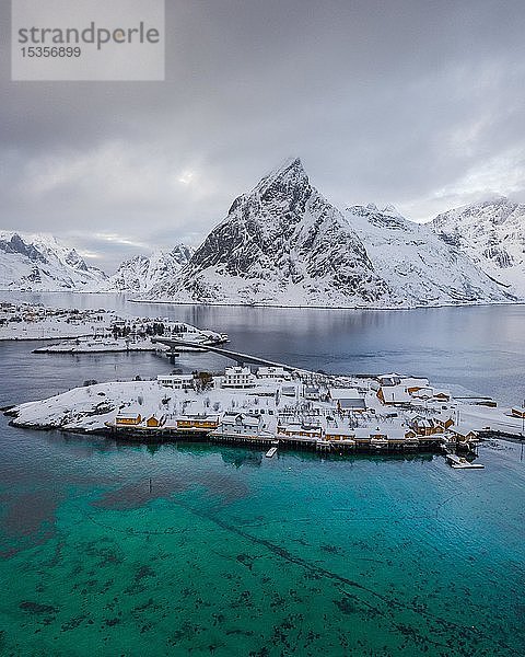Belbe Stelzenhäuser an türkisem Meer im Winter  Drohnenaufnahme  Sakrisoy  Lofoten  Norwegen  Europa