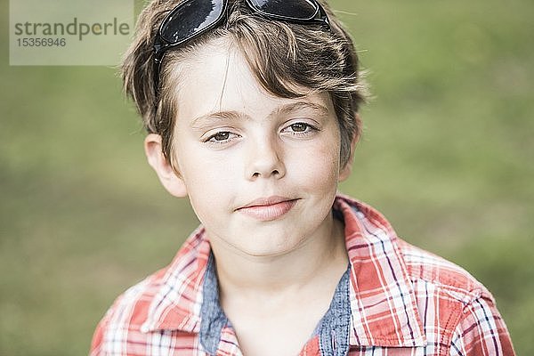 Junge  10 Jahre alt  mit Sonnenbrille und kariertem Hemd schaut cool in die Kamera  Portrait  Deutschland  Europa