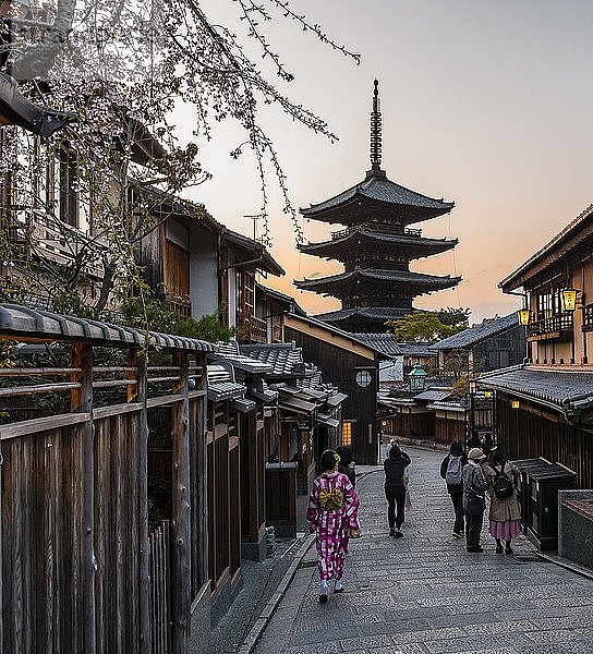 Fußgänger mit Kimono  Yasaka dori historische Straße in der Altstadt mit traditionellen japanischen Häusern  hinter fünfstöckiger Yasaka-Pagode des buddhistischen H?kanji-Tempels  Abendstimmung  Kyoto  Japan  Asien