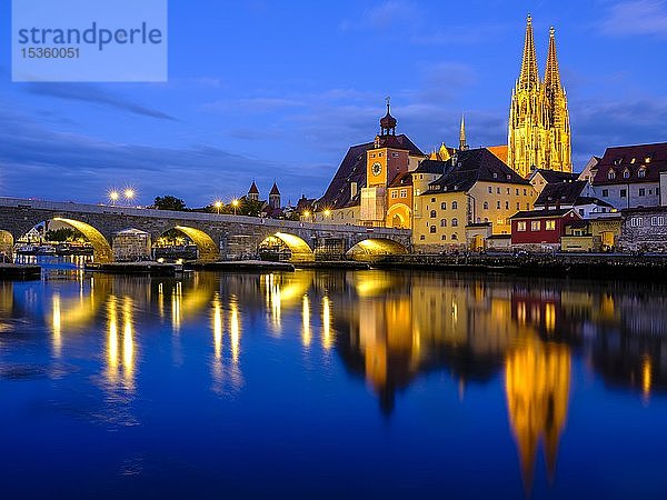 Beleuchtete Altstadt mit Steinerner Brücke und Dom  die sich in der Abenddämmerung in der Donau spiegeln  Regensburg  Oberpfalz  Bayern  Deutschland  Europa