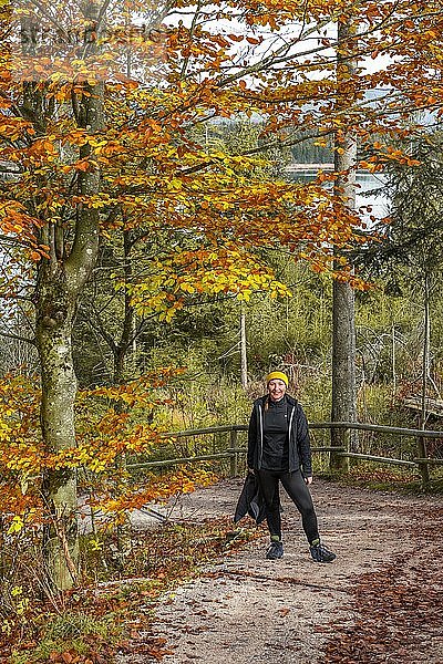 Junge Wanderin auf einem Wanderweg im Herbst  gelbes Laub  bei Krün  Oberbayern  Bayern  Deutschland  Europa
