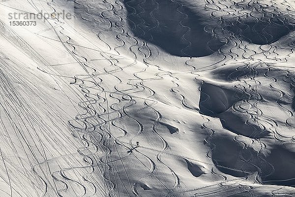 Skispuren und Tourengeher  die zwischen Skispuren auf tief verschneiten Hängen aufsteigen  Gramais  Lechtal  Tirol  Österreich  Europa