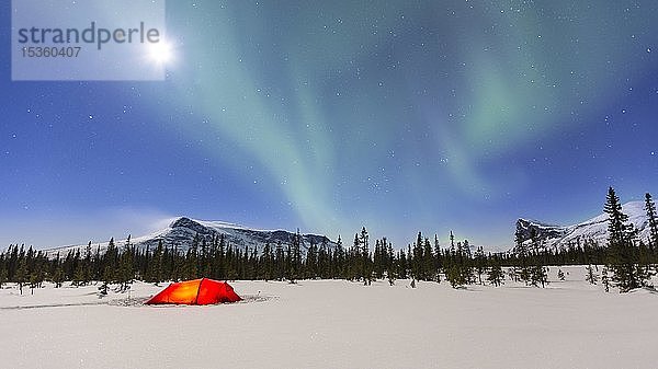 Nordlichter (Aurora borealis) über einem rot beleuchteten Zelt im Winter  Kungsleden  Provinz Lappland  Schweden  Europa