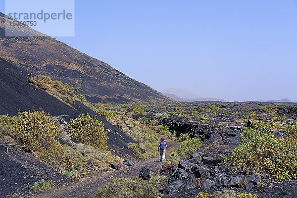 Frau geht auf Wanderweg durch Lavafeld  Naturpark Los Volcanes  bei Tinajo  Lanzarote  Kanarische Inseln  Spanien  Europa