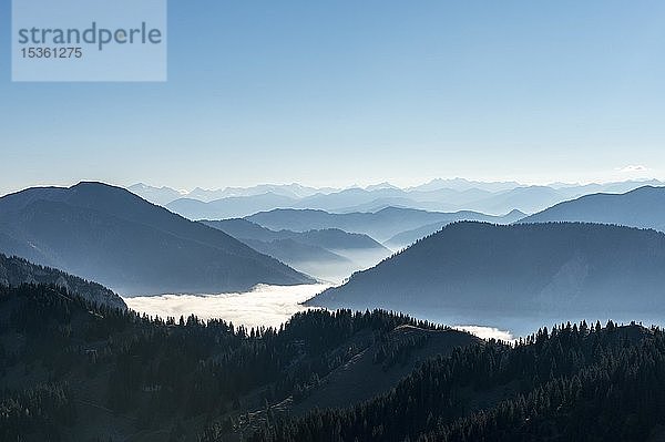 Bergketten hintereinander im Gegenlicht  Blick auf Alpenpanorama vom Gipfel des Breitensteins  Hochnebel über dem Tal  Fischbachau  Bayern  Deutschland  Europa