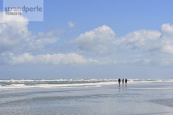 Spaziergänger am Strand bei stürmischer Nordsee  Juist  Ostfriesische Insel  Ostfriesland  Niedersachsen  Deutschland  Europa