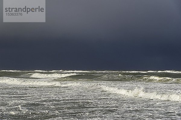 Wellen am Sandstrand vor einer Regenfront über der Nordsee  Sylt  Nordfriesische Inseln  Nordfriesland  Schleswig-Holstein  Deutschland  Europa