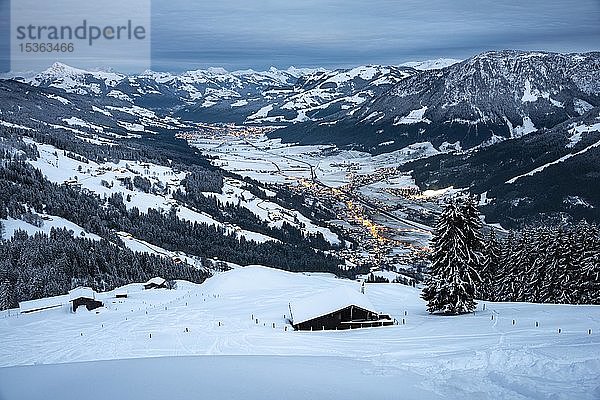 Blick auf das winterliche Brixental in der Abenddämmerung  schneebedeckte Berghütten im Vordergrund  Hochbrixen  Brixen im Thale  Tirol  Österreich  Europa