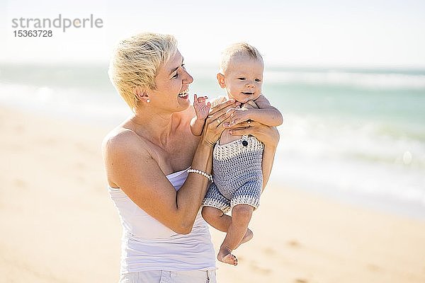 Attraktive blonde Mutter mit 4 Monate altem Babyjungen am Strand  Portugal  Europa