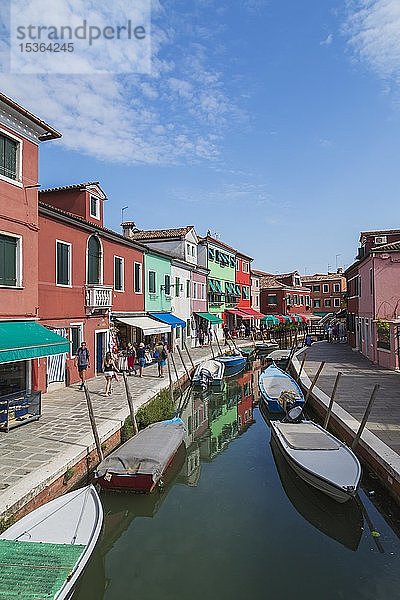 Festgemachte Boote am Kanal mit bunten Häusern  Geschäften und Touristen  Insel Burano  Venezianische Lagune  Venedig  Venetien  Italien  Europa