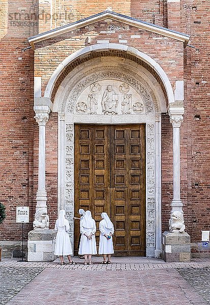 Nonnen betrachten die Porta Santa der Abteikirche San Silvestro  romanisch  Nonantola  Provinz Modena  Emilia-Romagna  Italien  Europa