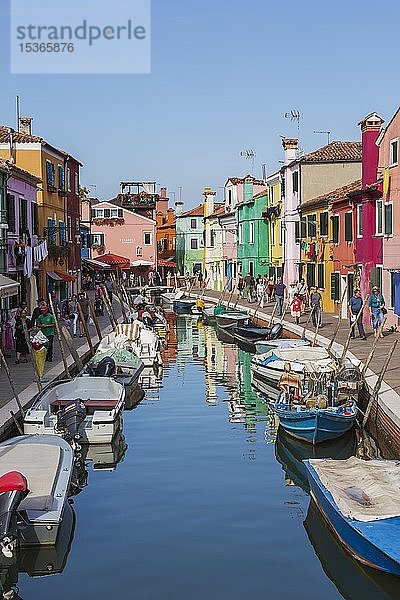 Festgemachte Boote am Kanal mit bunten Häusern  Geschäften und Touristen  Insel Burano  Venezianische Lagune  Venedig  Venetien  Italien  Europa