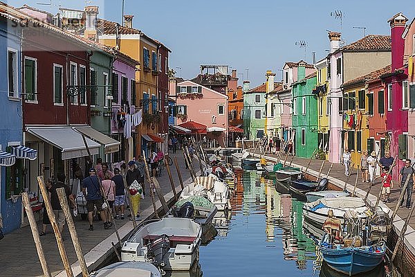 Festgemachte Boote am Kanal mit bunten Häusern  Geschäften und Touristen  Insel Burano  Venezianische Lagune  Venedig  Venetien  Italien  Europa