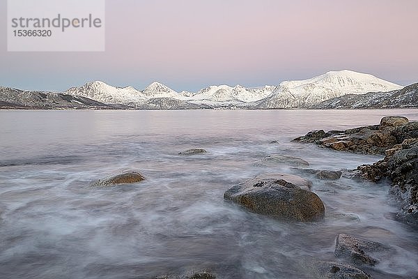 Küste im Abendlicht und schneebedeckte Berge  Sommaroy  Tromsö  Norwegen  Europa