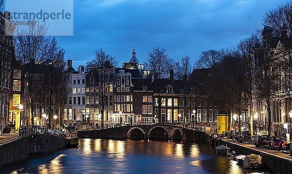Gracht mit Brücke und historischen Häusern in der Abenddämmerung  Amsterdam  Nordholland  Niederlande