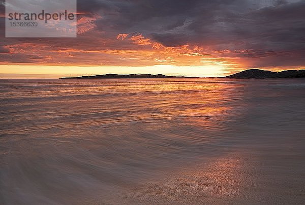 Wellenlauf am Sandstrand  dramatischer Sonnenuntergang mit bewölktem Himmel über dem Atlantischen Ozean  Isle of Harris  Schottland  Vereinigtes Königreich  Europa