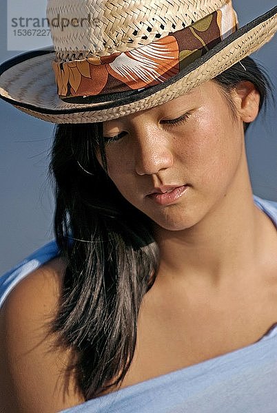 Junge asiatische Frau mit Strohhut am Strand  Porträt  Ibiza  Spanien  Europa
