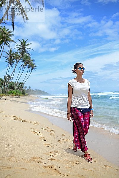 Junge Frau beim Spaziergang am Strand zwischen Weligama und Ahangama  Sri Lanka  Asien