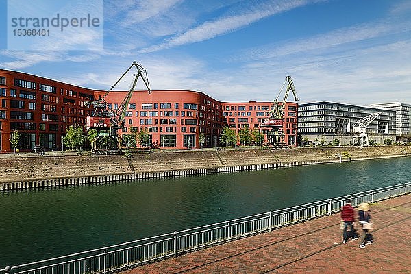 Innenhafen Duisburg mit dem wellenförmigen Gebäude des Landesarchivs NRW  anderen modernen Bürogebäuden und alten Hafenkränen  Duisburg  Ruhrgebiet  Nordrhein-Westfalen  Deutschland  Europa