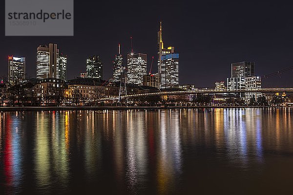 Skyline von Frankfurt mit beleuchteten Wolkenkratzern und Spiegelungen im Main  Schaumainkai  Frankfurt am Main  Hessen  Deutschland  Europa