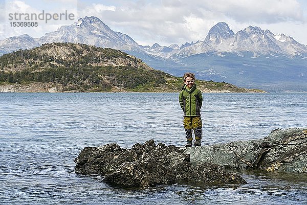 Kleiner Junge auf Felsen am Ufer des Beagle-Kanals  Fin del Mundo  Ende der Welt  Parque Nacional Tierra del Fuego National Park  Anden  Feuerland  Argentinien  Südamerika