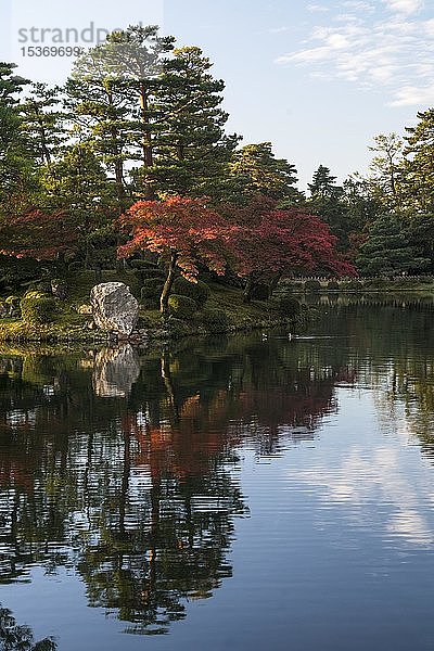 Bäume mit roten Herbstblättern am Wasser  Kenrokuen-Garten  Kanazawa  Japan  Asien