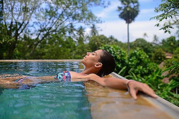 Junge Frau genießt ein Bad in einem Swimmingpool  Galle  Sri Lanka  Asien