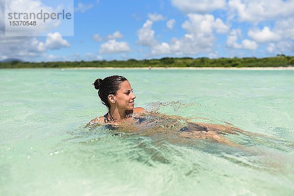 Junge Frau beim Schwimmen im Wasser  Strand Kondoi  Insel Taketomi  Präfektur Okinawa  Japan  Asien