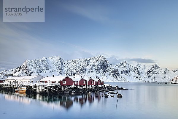 Rorbuer Hütten von Hamnoy  hinter verschneiten Bergen  Hamnøy  Moskenesøya  Lofoten  Norwegen  Europa