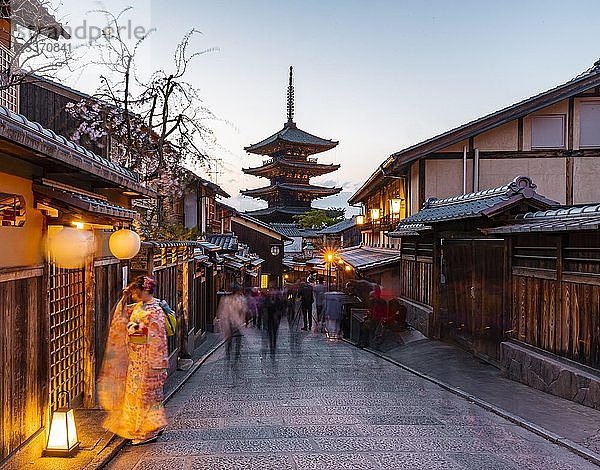 Frau im Kimono und Fußgänger in einer Gasse  Yasaka dori historische Gasse in der Altstadt mit traditionellen japanischen Häusern  hintere fünfstöckige Yasaka-Pagode des buddhistischen H?kanji-Tempels  Abendstimmung  Kyoto  Japan  Asien