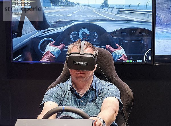 Besucher trägt eine Virtual-Reality-Brille in einem Fahrsimulator für Autorennen auf der gamescom  der weltweit größten Messe für Video- und Computerspiele in Köln  Deutschland  Europa