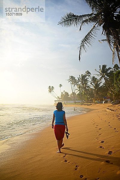 Junge Frau beim Spaziergang am Strand von Hikkaduwa  Sri Lanka  Asien