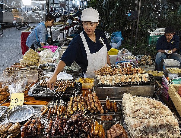 Verkäuferin mit Fleisch- und Wurstspießen auf dem Markt  Thailändische Küche  Thailand  Asien