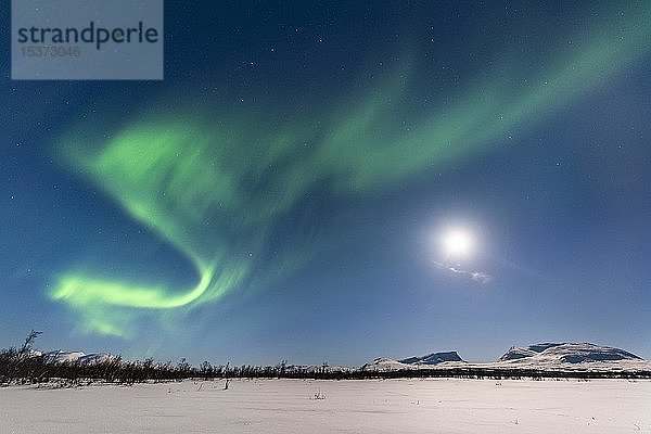 Nordlicht (Aurora Borealis) bei Vollmond über schneebedeckten Bergen  Lapporten  Abisko National Park  Abisko  Lappland  Schweden  Europa