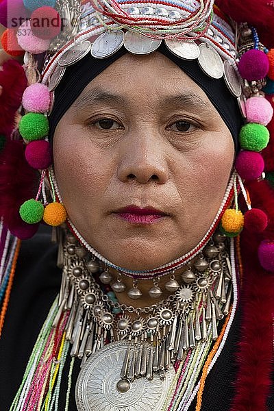 Akha-Frau mit Kopfschmuck  Kopfbedeckung mit Silbermünzen  traditionelle Kleidung  Porträt  Provinz Chiang Rai  Nordthailand  Thailand  Asien