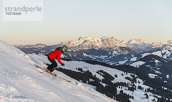 Skifahrerin auf der Skipiste an einem steilen Hang  hinter Bergen  SkiWelt Wilder Kaiser  Brixen im Thale  Tirol  Österreich  Europa