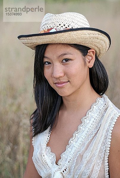 Junge asiatische Frau mit Strohhut in der Natur  Porträt  Ibiza  Spanien  Europa