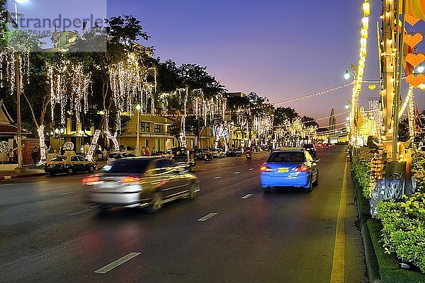 Beleuchtete  mit Lichtern geschmückte Straße mit Autoverkehr in der Abenddämmerung  Rachadamnoen Klang Road  Bangkok  Thailand  Asien