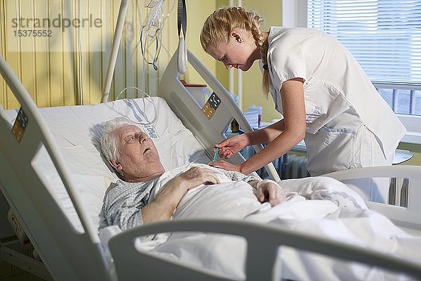 Krankenschwester kümmert sich um einen Patienten in einem Krankenhausbett  Tschechische Republik  Europa