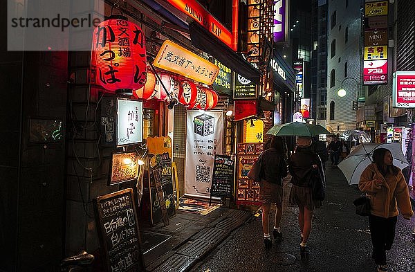 Fußgänger  Fahrbahn mit Leuchtreklame  Papierlaternen und Werbeschildern bei Nacht  Udagawacho  Shibuya  Tokio  Japan  Asien