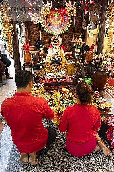 Paar  das im Innenhof des Tempels Wat Phnom Daun Penh Opfergaben darbringt  Chinesisches Neujahr  Phnom Penh  Kambodscha  Asien