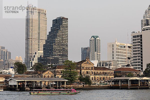 Skyline des Stadtteils Bang Rak  vor der alten Feuerwache Bangrak  Boot auf dem Mae Nam Chao Phraya  Bangkok  Thailand  Asien