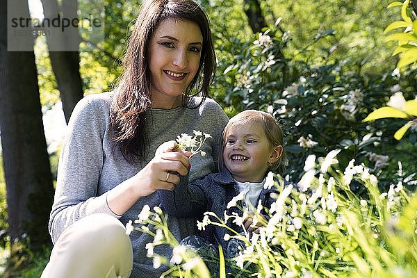Mutter sitzt mit kleiner Tochter auf einer Blumenwiese  Tschechische Republik  Europa