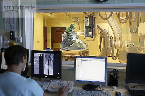 Interventionelle Radiologie  Arzt überwacht Kollegen während einer Operation am Monitor  Karlovy Vary  Tschechische Republik  Europa