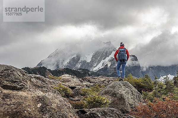 Wanderin schaut in die Ferne  Berglandschaft im Herbst  Gletscher im Rücken Mt. Shuksan mit Schnee in Wolken  Mt. Baker-Snoqualmie National Forest  Washington  USA  Nordamerika